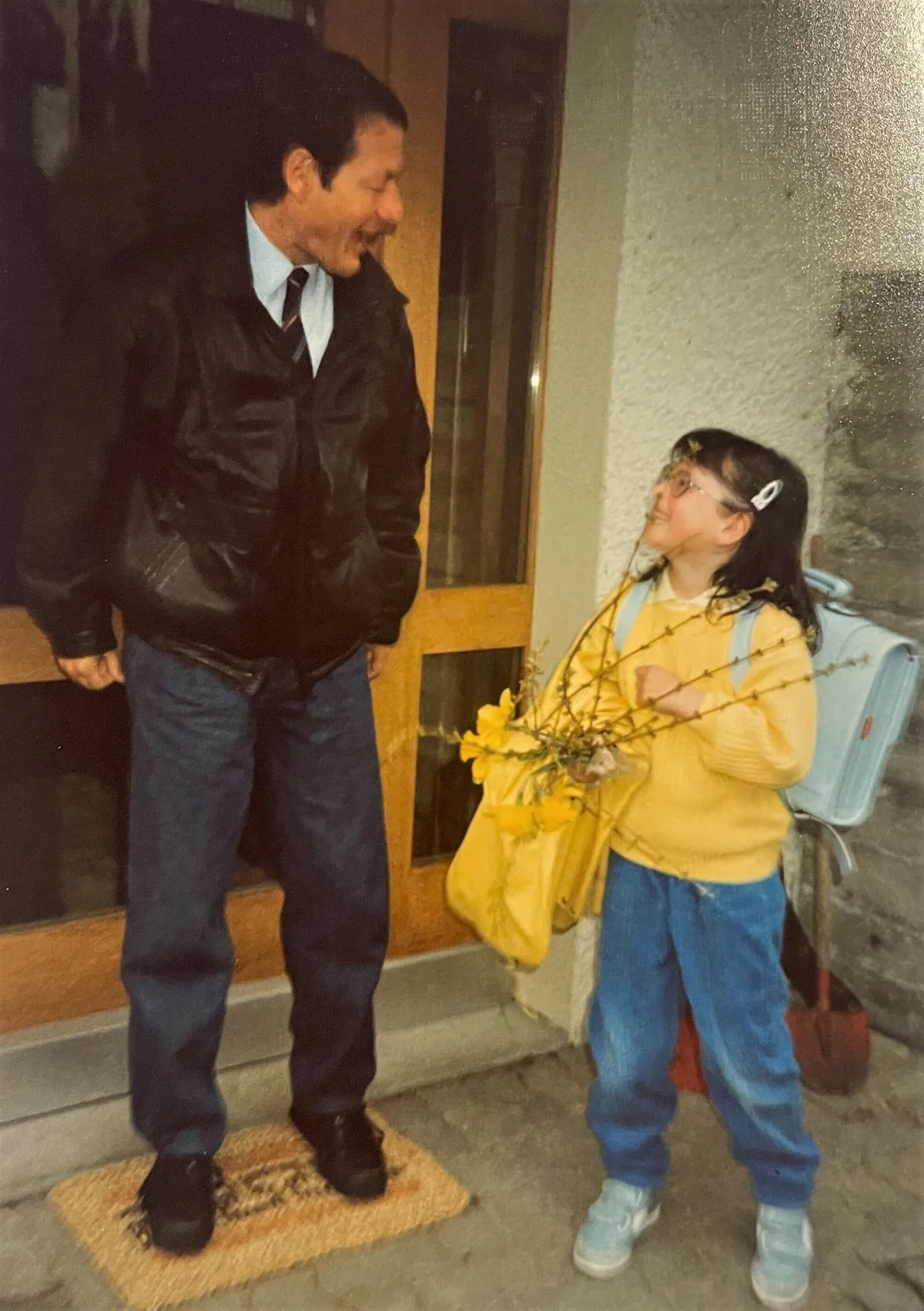 Man sieht ein Mädchen mit seinem Vater am ersten Schultag.